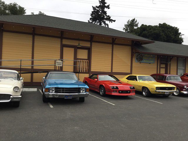 A group of classic cars parked in front of a building.