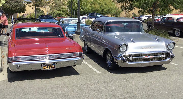 Two classic cars parked in a parking lot.