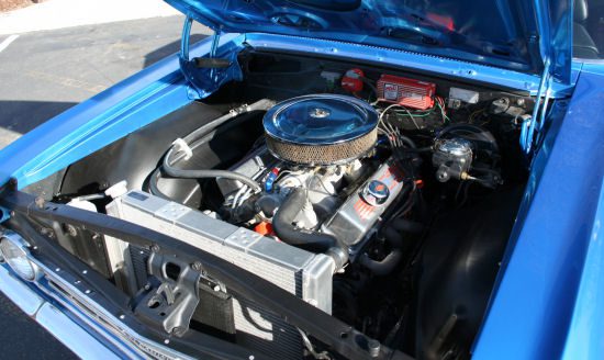 A blue car with a blue engine in the hood.