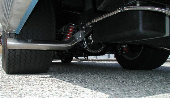 The rear end of a truck with a chrome exhaust pipe.