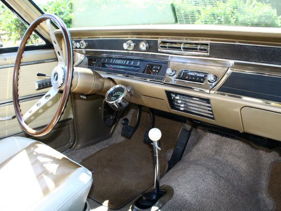 The interior of a beige car with a steering wheel and steering wheel.
