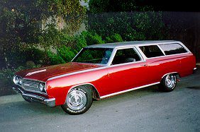 A red station wagon is parked in front of a house.