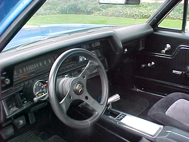 The interior of a blue car with a steering wheel and steering wheel.