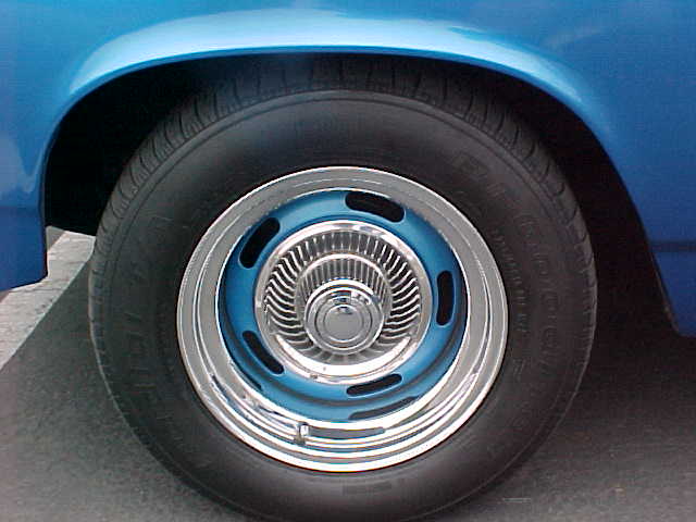 A blue car with chrome wheels and rims.