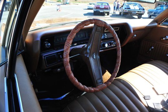 The interior of a classic car with leather seats and steering wheel.