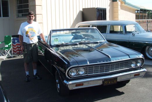 A man standing next to a black car.