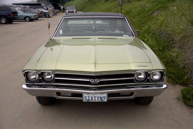 A green chevrolet chevelle parked on the side of the road.