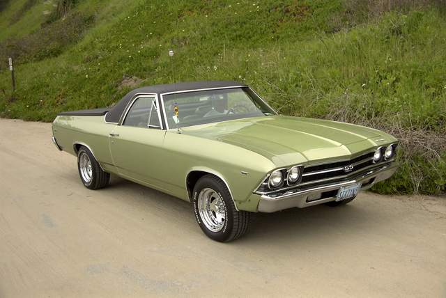 A green chevrolet chevelle is parked on the side of the road.