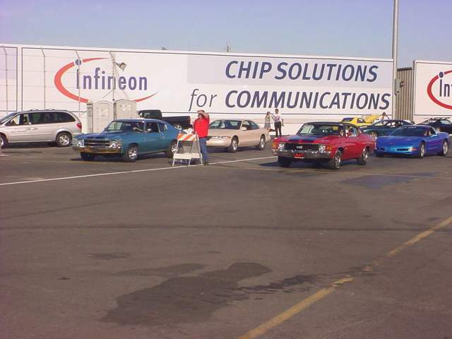 A lot of cars parked in front of a building with a sign that says chip solutions for communications.