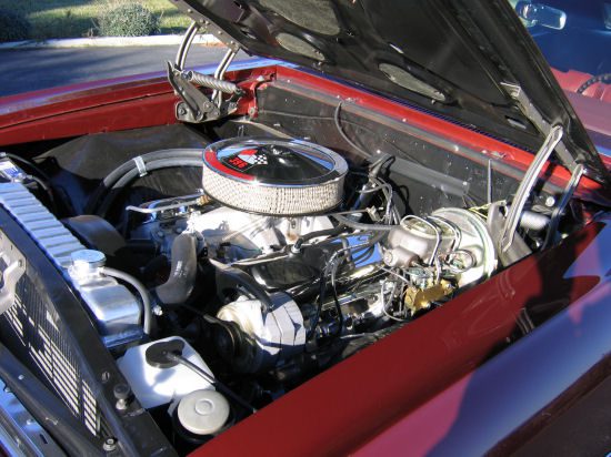 The hood of a classic car with a red engine.