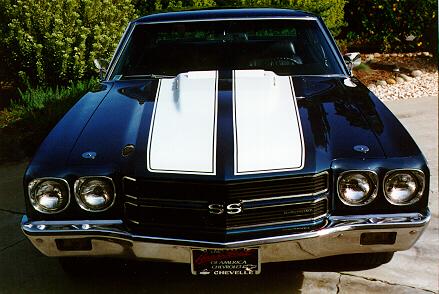 A black and white chevrolet chevelle parked in a driveway.