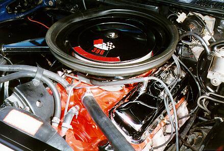 The engine compartment of a car with a black hood.
