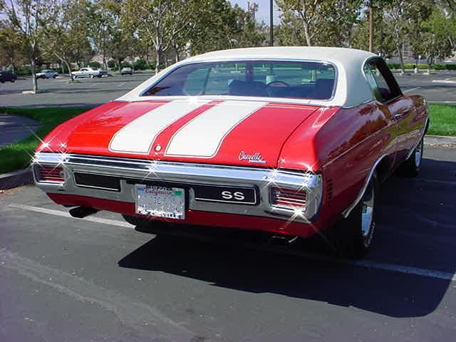 A red and white muscle car parked in a parking lot.