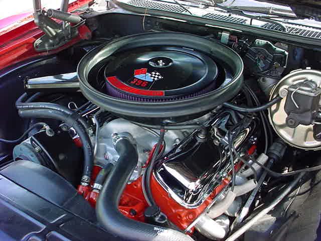 The engine compartment of a red car.