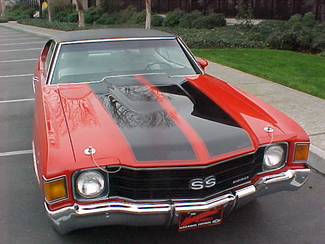 A red and black chevrolet chevelle parked in a parking lot.
