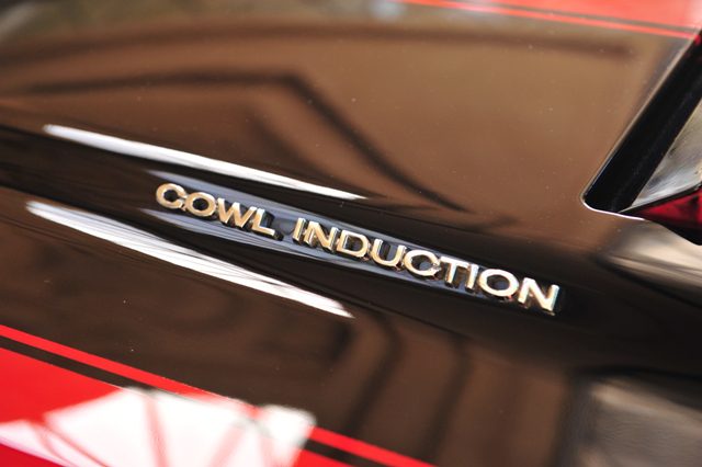 A close up of the ocw induction logo on a red car.